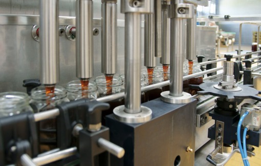 Napełnianie słoików miodem na linii produkcyjnej w trakcie procesu konfekcjonowania